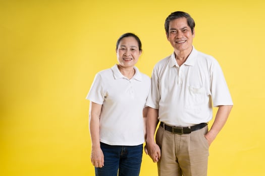 portrait of middle aged asian couple posing on yellow background photo