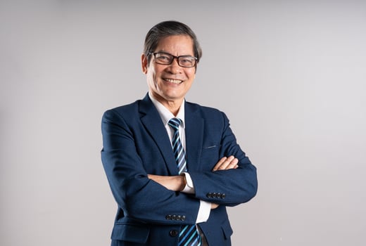 Portrait of an elderly Asian businessman, posing on a blue background photo