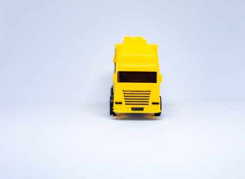 Yellow toy cement mixer truck on white background photo