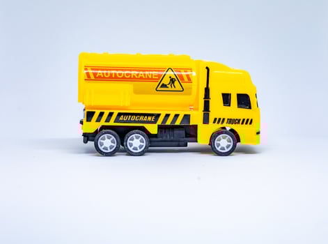 Yellow toy cement mixer truck on white background photo