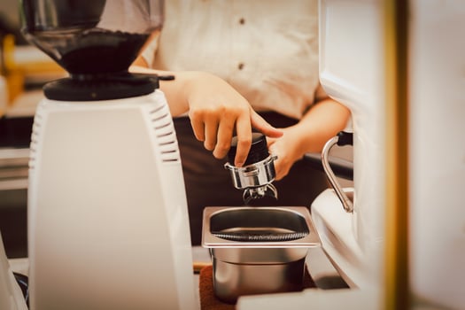 Barista preparation tampering coffee in portafilter for making fresh coffee. photo