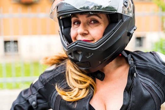 portrait of mature woman with motorcycle helmet outdoors photo