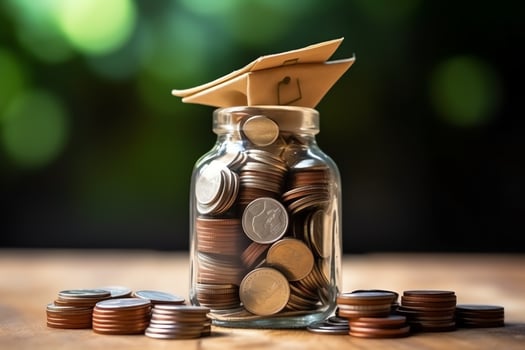 A glass bottle with stack of coins money and a graduation hat on top. Saving money and educational success concept by AI Generated photo