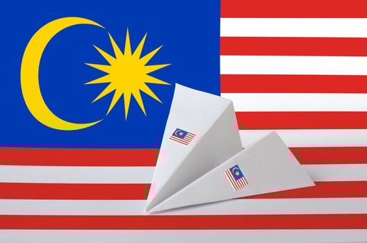 Malaysia flag depicted on paper origami airplane. Handmade arts concept photo