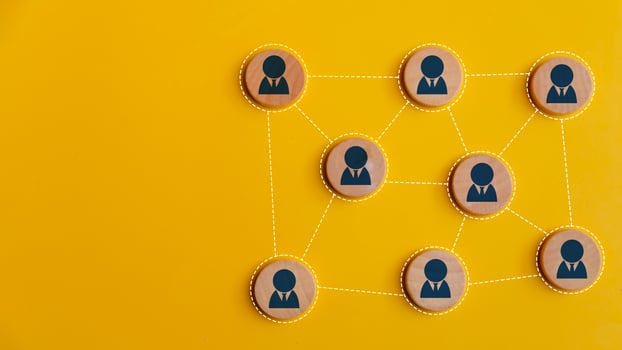Wooden blocks connected together on a yellow background. Teamwork, network, and community concept. photo