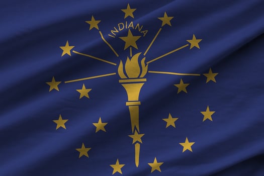 Indiana US state flag with big folds waving close up under the studio light indoors. The official symbols and colors in banner photo