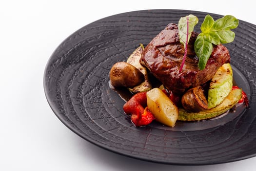 gourmet appetizing roasted beef steak with potato wedges and other vegetables photo