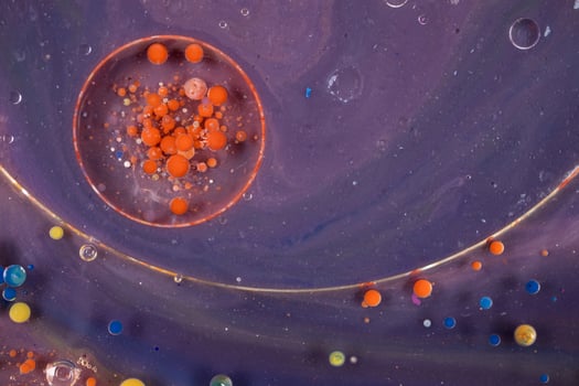 Acrylic paint balls abstract texture. Bright colors fluid, flowing wallpaper design. Purple, blue, pink and yellow liquids mix. photo