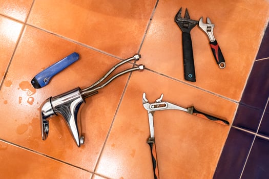 removed faucet on ceramic tiles on bathroom floor photo