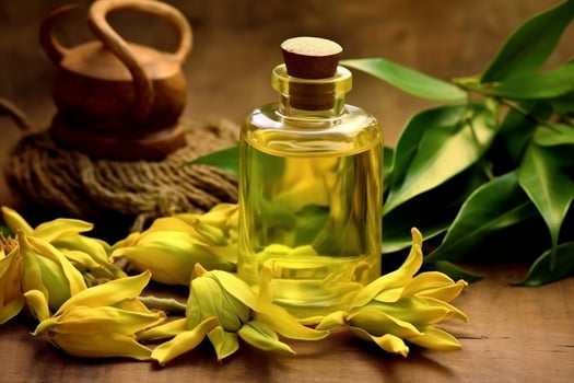 ylang ylang or cananga odorata flower essential oil alongside ylang ylang or cananga odorata flower on a table photo