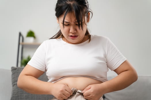 Fat chubby woman trying to wear tight pants, overweight, weight gain, Healthy and medical concept. photo