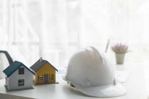 Construction engineers place plans and model homes  on desks in their offices for real estate agents to view the plans they want construction engineers to build on budget and meet client needs. photo