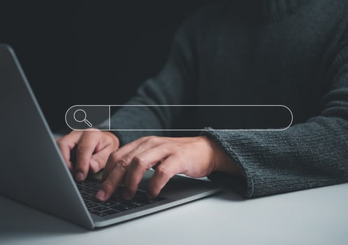 Human hand working on computer and search icon. The concept of searching for information from the internet network. photo