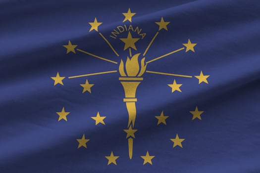 Indiana US state flag with big folds waving close up under the studio light indoors. The official symbols and colors in banner photo
