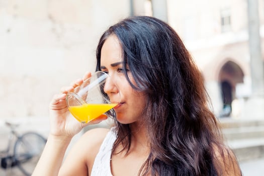 portrait of attractive girl while drinking an orange juice photo
