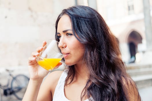 portrait of attractive girl while drinking an orange juice photo