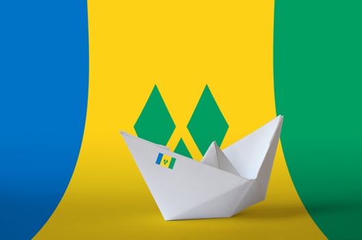 Saint Vincent and the Grenadines flag depicted on paper origami ship closeup. Handmade arts concept photo