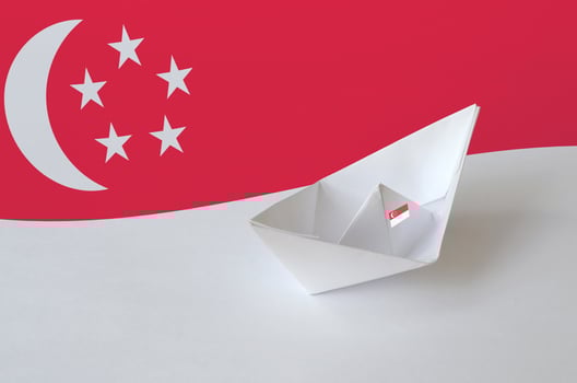 Singapore flag depicted on paper origami ship closeup. Handmade arts concept photo