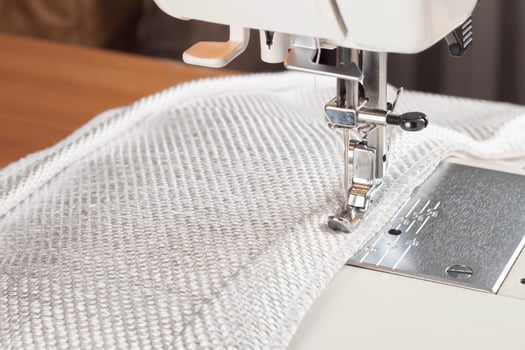 sewing machine. the process of sewing a decorative cord of white fabric. photo