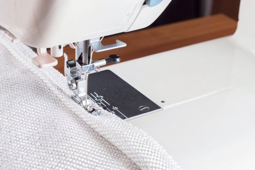 sewing machine. the process of sewing a decorative cord of white fabric. photo