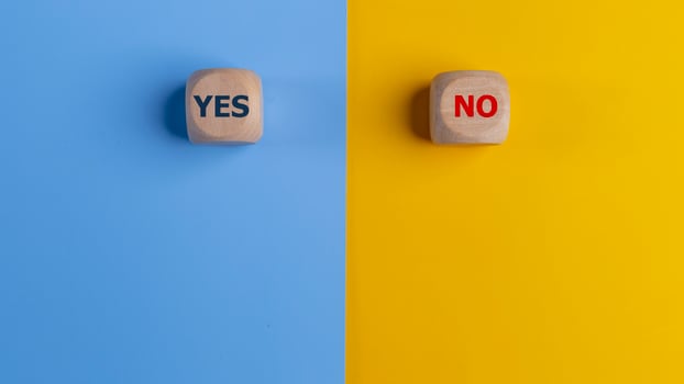 Wooden cube with yes and no text on a blue and yellow background. Business Choices For Difficult Situations, making Decisions. photo