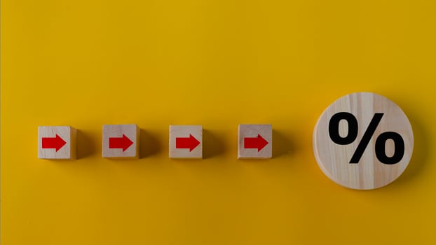 Percent and upwards increasing arrows on wooden cubes. Financial interest mortgage rates increase or price commission raise concept. photo