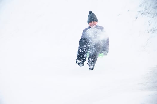 Child sledding cheesecake.Sledding off a snow slide photo