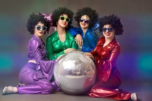 Group of happy girls in disco style, with disco ball, halloween party, on gray background. 80s themed party. photo