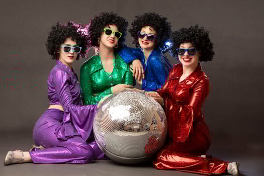 Group of happy girls in disco style, with disco ball, halloween party, on gray background. 80s themed party. photo