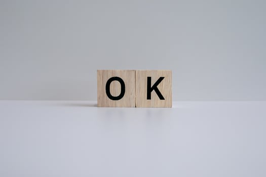 Wooden blocks form the text OK against a white background. photo