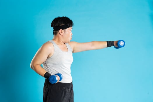 Image of Asian man exercising on blue background photo
