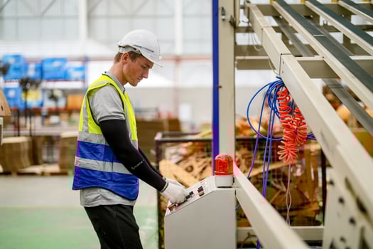 A worker in a factory using a machine photo