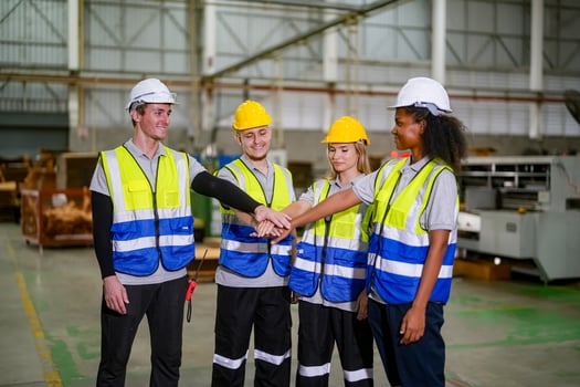 Four people in safety vests shaking hands photo