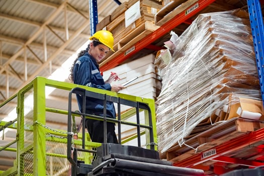 A worker on a forklift in a warehouse photo