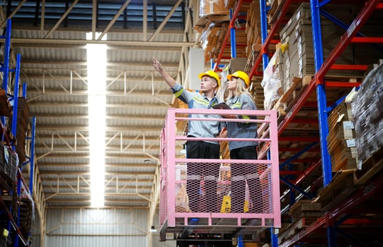 Two people on a forklift in a warehouse photo