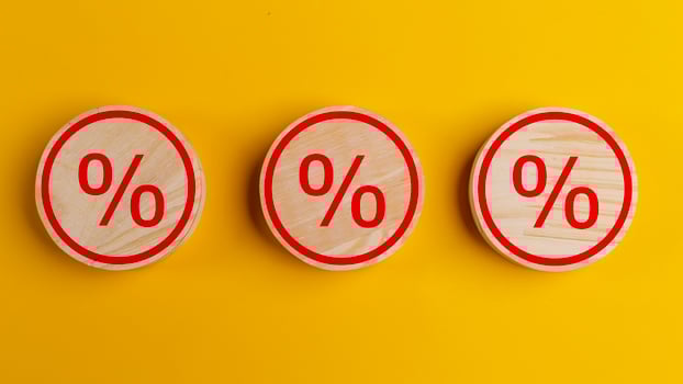 Percent sign on wooden cubes against yellow background with copy space. Concept of sale and discount. photo
