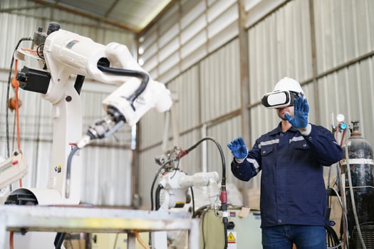 A man wearing a vr headset and standing next to a robot photo