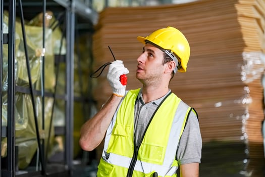 A man in a safety vest holding a radio photo