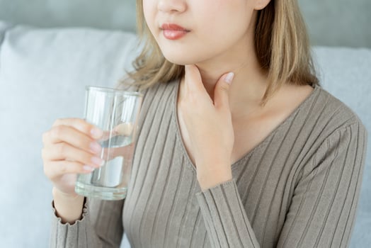 Asian woman put her hand on her neck due to a sore throat. female tonsillitis causes a inflammation. treated by taking water, taking antibiotics, consult a doctor, virus, corona virus, Influenza, flu photo