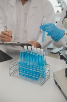 Health care researchers working in life science laboratory. Young female research scientist and senior male supervisor preparing and analyzing microscope slides in research lab. photo