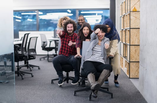 multiethnics business team racing on office chairs photo