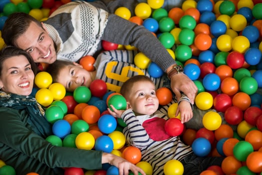 parents and kids playing in the pool with colorful balls photo