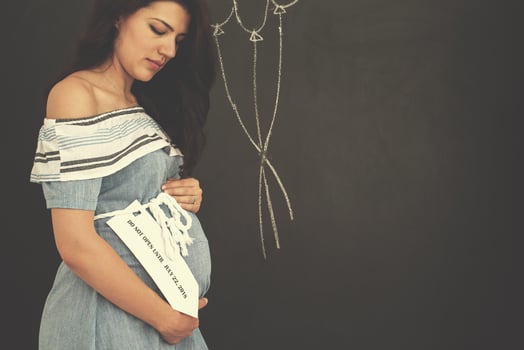 Portrait of pregnant woman in front of black chalkboard photo