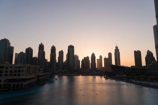 Dubai singing fountains at night lake view between skyscrapers. City skyline in dusk modern architecture in UAE capital downtown. photo