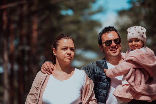 Family fun in the park. Happy family spending time in park and playing with their daughter photo