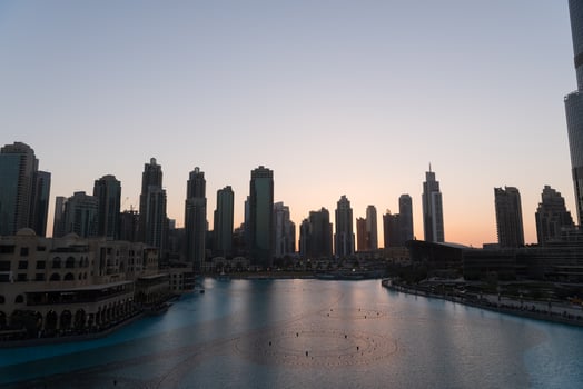 Dubai singing fountains at night lake view between skyscrapers. City skyline in dusk modern architecture in UAE capital downtown. photo
