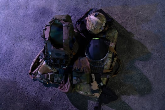 Army body armor, helmet and ammunition, Kalashnikov assault rifle with matrons and first aid tourniquet composition on brown wood. Army body armor. flat laying. military concept. photo