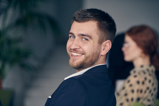 A smiling entrepreneur sits in a modern office, actively participating in a business meeting, radiating confidence and professionalism. photo