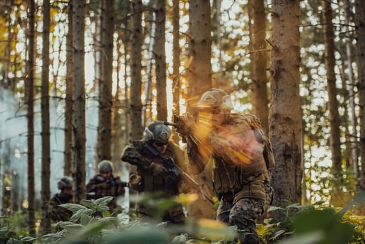 A group of modern warfare soldiers is fighting a war in dangerous remote forest areas. A group of soldiers is fighting on the enemy line with modern weapons. The concept of warfare and military conflicts photo