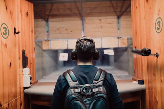 A man practices shooting a pistol in a shooting range while wearing protective headphones photo